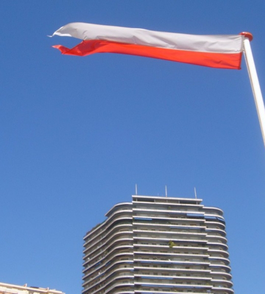 ROUGE ET BLANC, LE DRAPEAU DE MONACO FLOTTE DANS UN CIEL AZUR